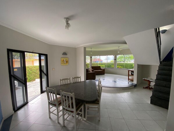 Una habitación amplia con una mesa de comedor, sillas, un sofá y una escalera.