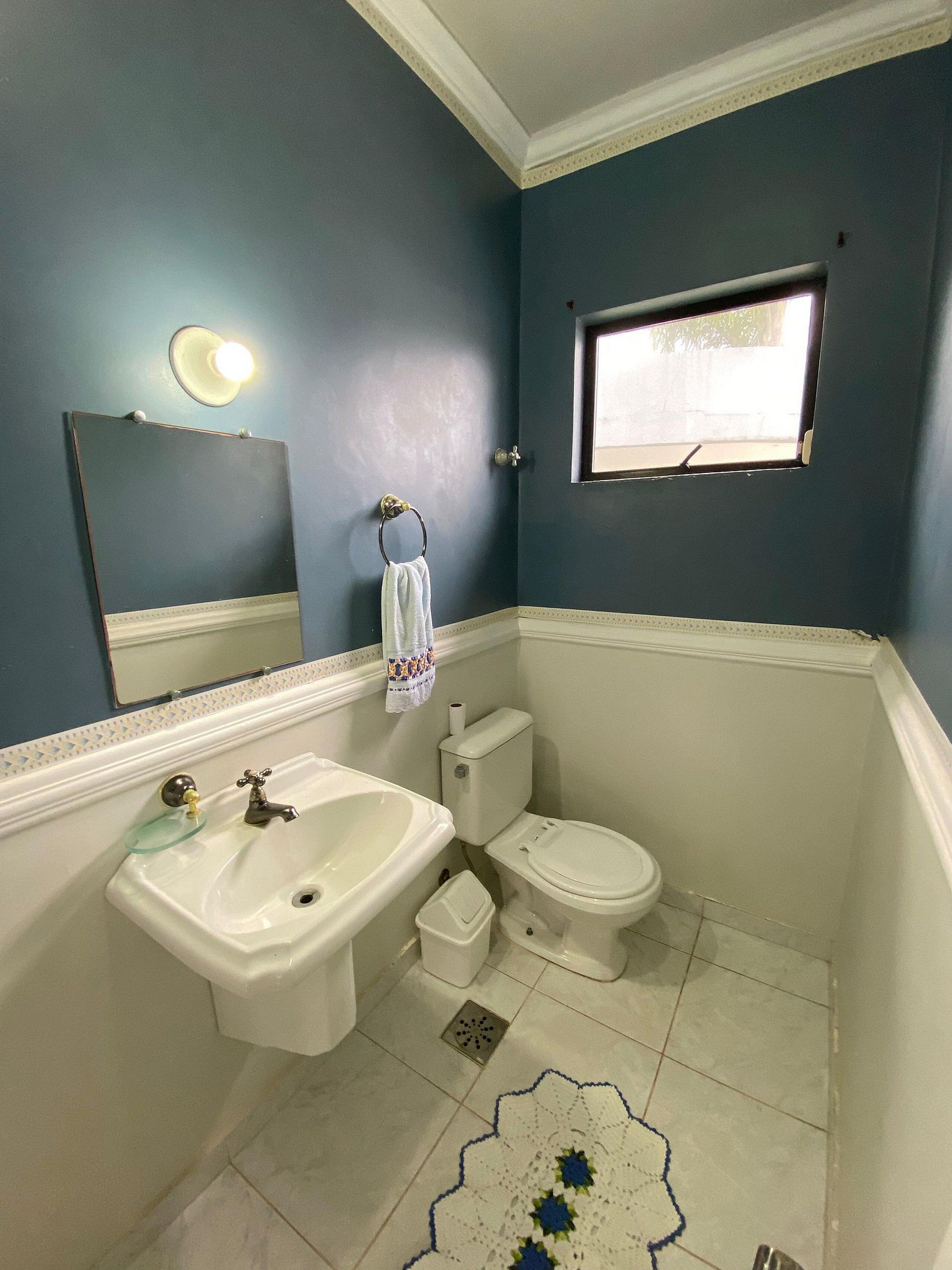 Ein Badezimmer mit Waschbecken, Toilette und Spiegel.