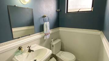 Ein Badezimmer mit Waschbecken, Toilette und Spiegel.