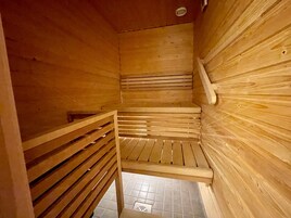 Puinen sauna, jossa on kalteva lattia ja penkki.