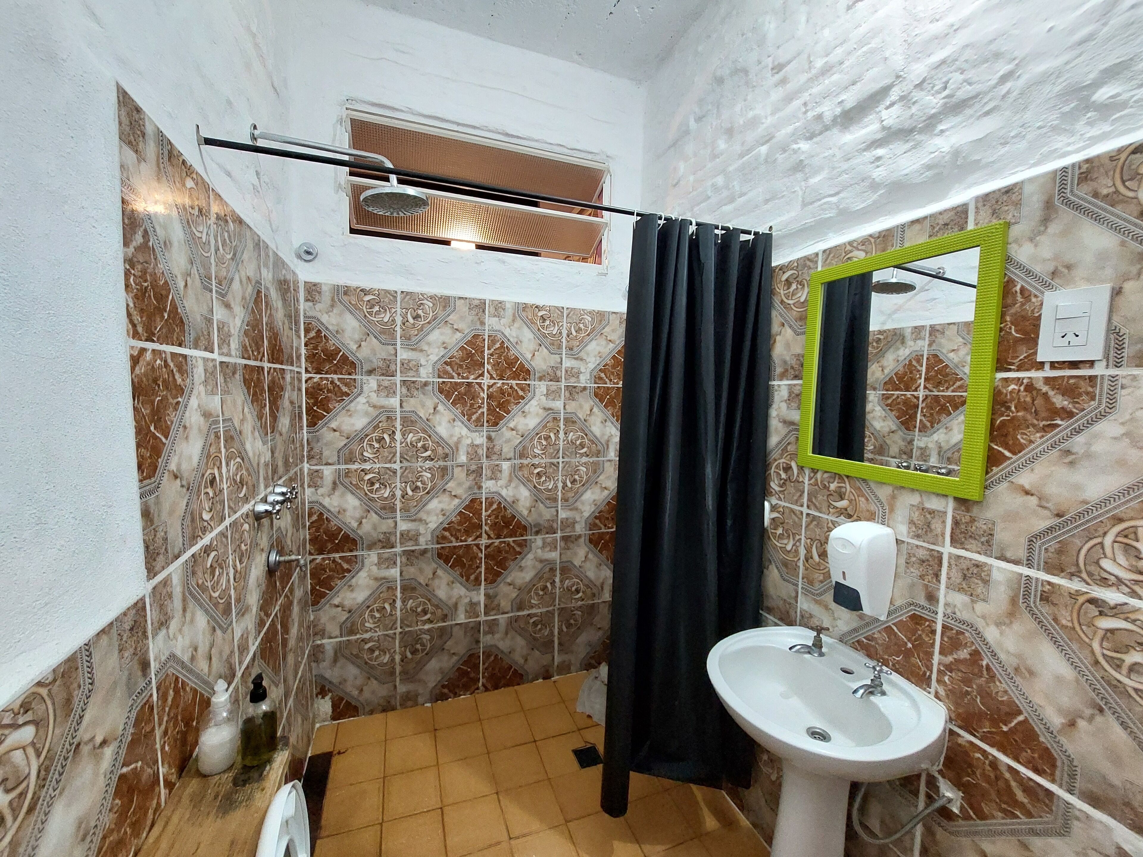 A bathroom with a shower, a sink, and a mirror.