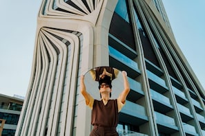 Un edificio moderno con un diseño arquitectónico único, que presenta líneas curvas y una combinación de materiales de vidrio y hormigón.