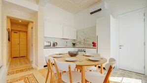 Una cocina moderna con armarios blancos, una mesa de comedor redonda y un suelo con diseño.