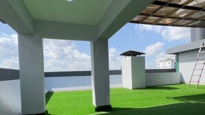 Una terraza amplia en la azotea con césped artificial, vistas al mar y un diseño arquitectónico moderno.