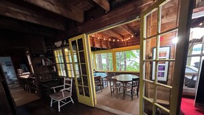 Un intérieur en bois comprenant un coin repas, une cuisine et une vue sur l’extérieur.