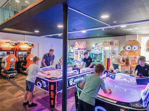 A brightly lit arcade with various gaming machines, including a prominent Minion character decoration. - Serenity Shores - Billing Aquadrome (Northampton)