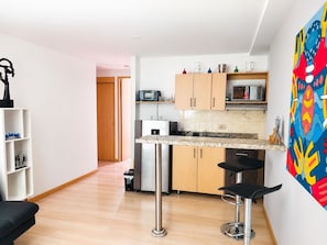 A modern kitchen with a marble countertop, wooden cabinets, and a stainless steel sink. - Medellin, Bring your toothbrush, in Laureles (Medellín)