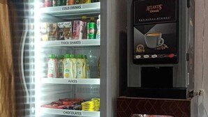 A vending machine with a Celfrost refrigerator stocked with beverages and snacks. - Laxmi Dormitory | 2 mins walk from Prem Mandir (Vrindavan)