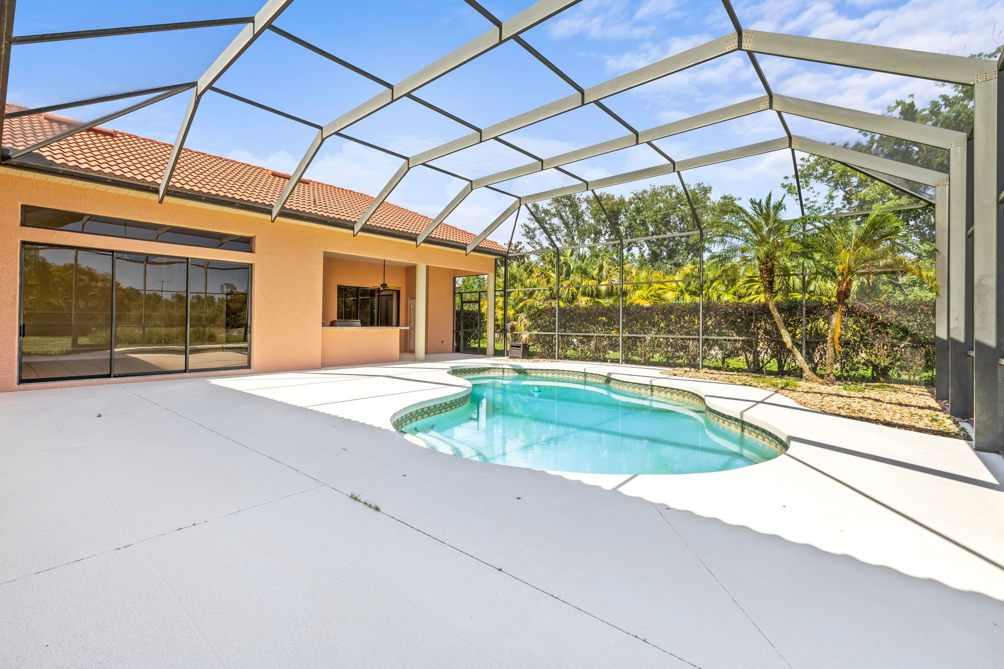 A modern house with a swimming pool, large glass windows, and a covered patio area.