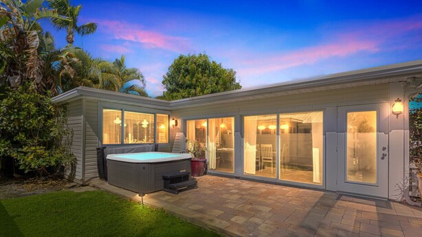 A modern house with a hot tub, large sliding glass doors, and a well-maintained garden. - Rowdy Rooster ~Steps to Atlantic ~ Hot Tub (Delray Beach)