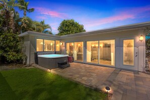 A modern house with a hot tub, large sliding glass doors, and a well-maintained garden. - Rowdy Rooster ~Steps to Atlantic ~ Hot Tub (Delray Beach)