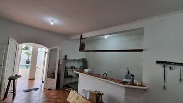 Una cocina con mostrador, refrigerador y pileta.