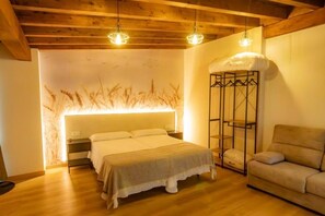 Une chambre à coucher comprenant un lit, des tables de chevet, un canapé et un mur décoratif.