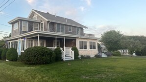 Una casa de dos pisos con porche, garaje y césped bien cuidado.