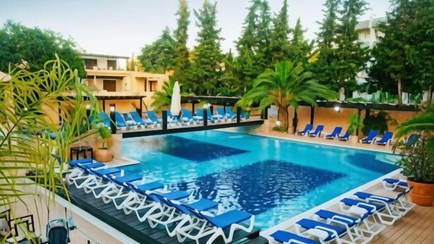 A swimming pool with lounge chairs and potted plants.