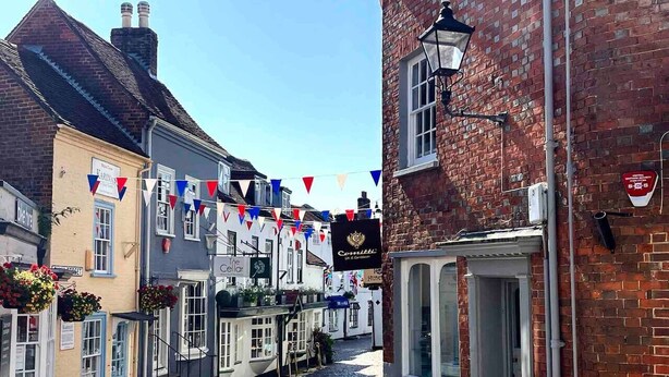 A narrow cobblestone street lined with traditional buildings, including a pub with a sign reading "The Cellar." - Peppercorn  An Enchanting house in Lymington (Hampshire)