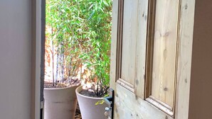 A doorway leading to a garden with two potted plants. - Peppercorn  An Enchanting house in Lymington (Hampshire)