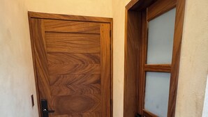Un couloir avec une porte en bois et une porte en verre dépoli.