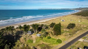 A coastal landscape with a beach, a road, and scattered buildings.