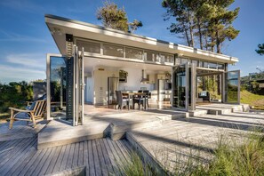 A modern house with a glass-enclosed patio, a dining area, and a kitchen.