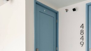 A blue door with a numeric keypad lock, a welcome mat, and a doorbell camera. - West Seattle Junction • Private Parking • Walkable • 15 mins from Downtown (Seattle)