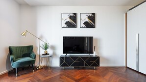 A living room with a green sofa, a black TV stand, and two abstract paintings on the wall. - American Embassy Luxury 2 Bed 2 Bath Top Location! (London)