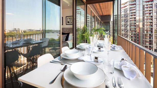 A dining area with a table set for four, large windows, and a view of a cityscape. - American Embassy Luxury 2 Bed 2 Bath Top Location! (London)