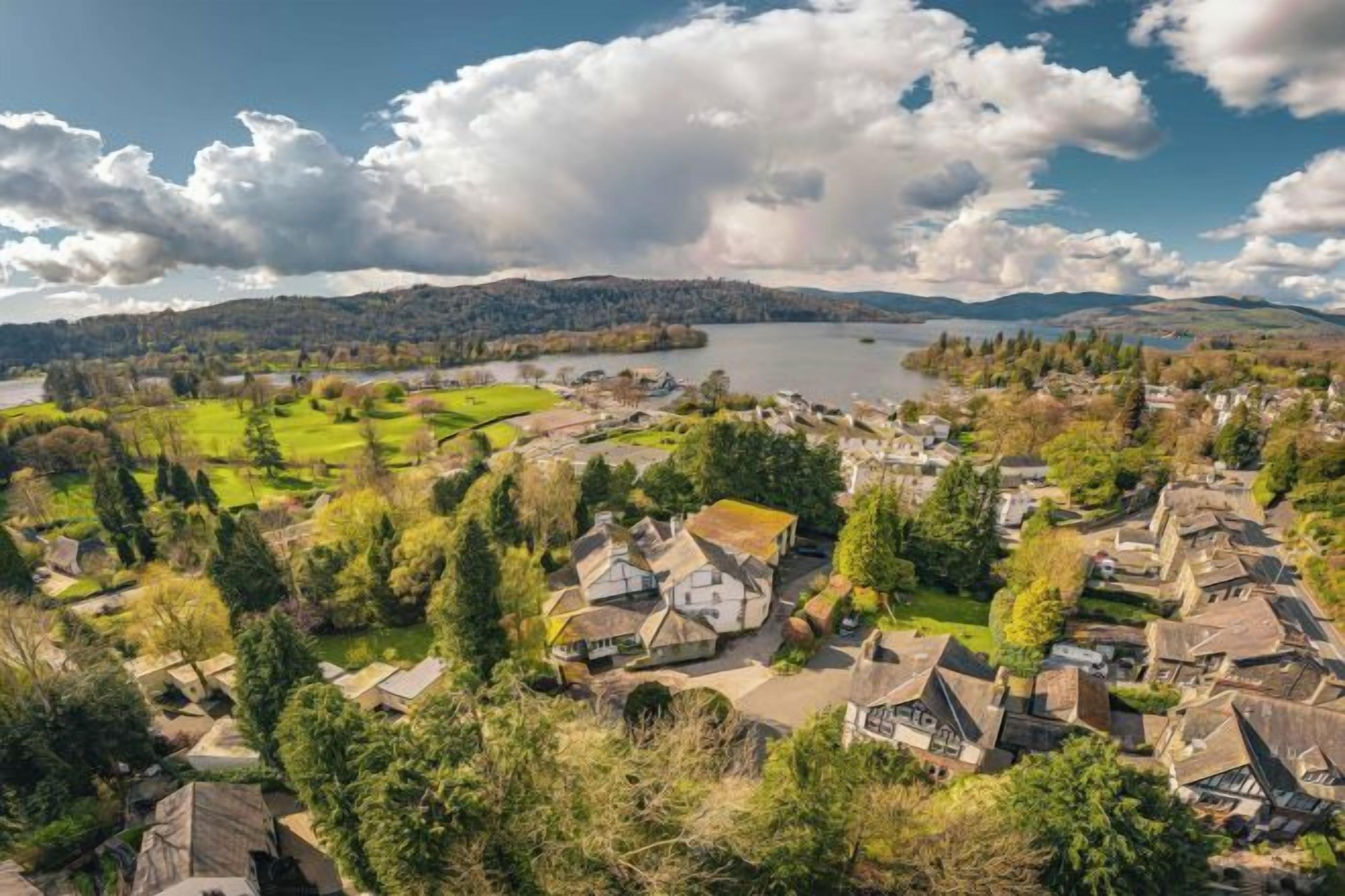 A coastal town with houses, a lake, and a hilly landscape.