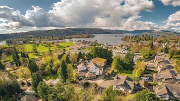A coastal town with houses, a lake, and a hilly landscape.