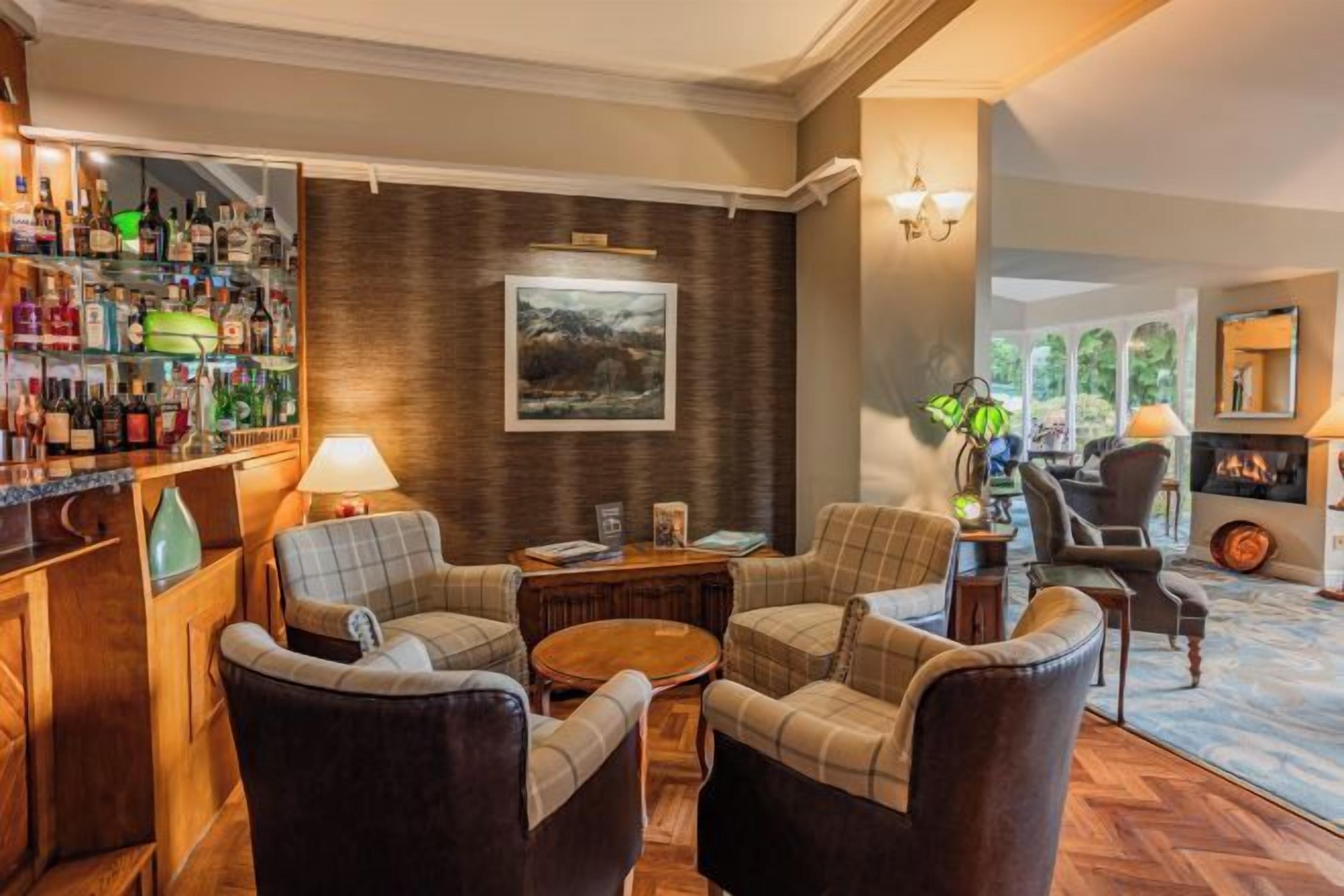 A bar area with a variety of bottles, a fireplace, and seating arrangements.