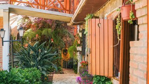 Un jardín con un sendero de piedra, plantas en macetas y una cerca de madera.