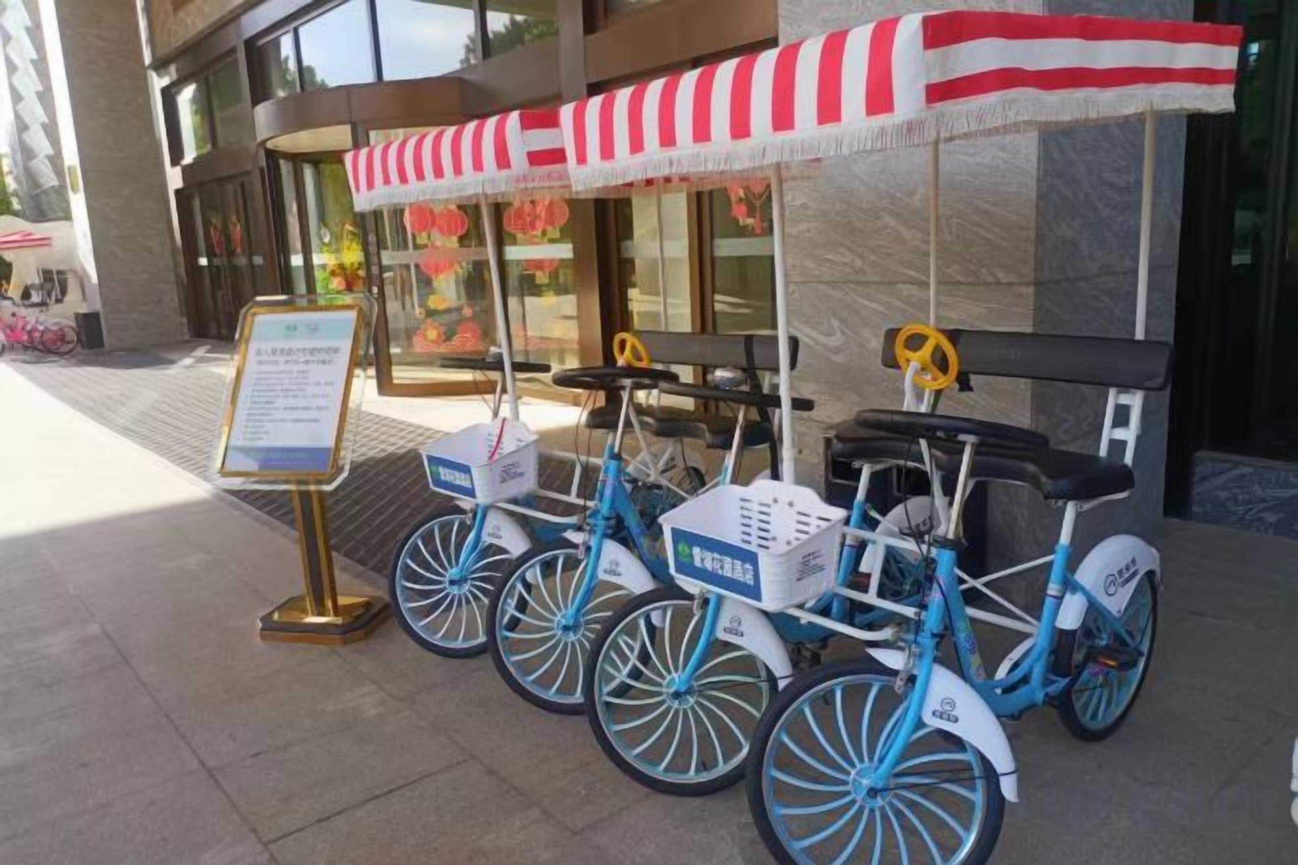 A blue bicycle with a red and white canopy, a sign, and a basket.