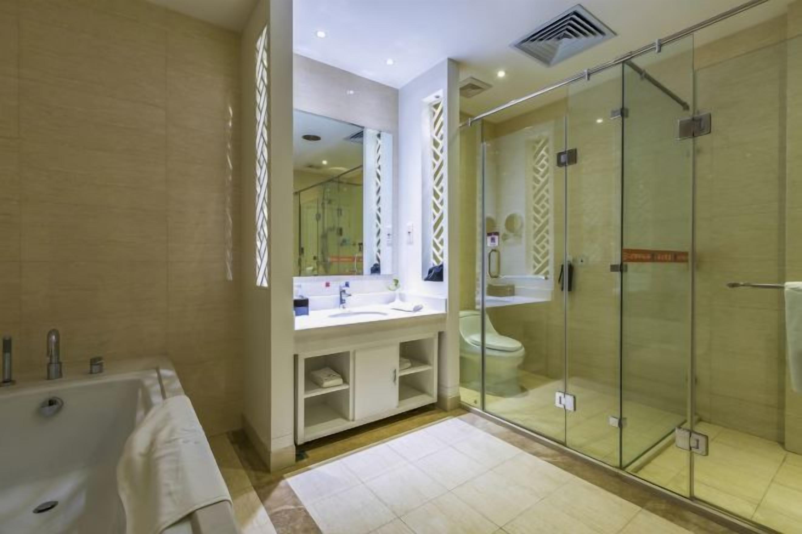 A modern bathroom with a glass-enclosed shower, a freestanding bathtub, and a vanity with a mirror.