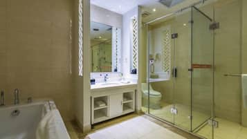 A modern bathroom with a glass-enclosed shower, a freestanding bathtub, and a vanity with a mirror.