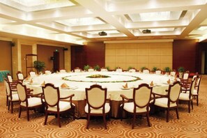 A conference room with a round table, chairs, and a carpeted floor. - Xuehu Garden Hotel (Jinan)