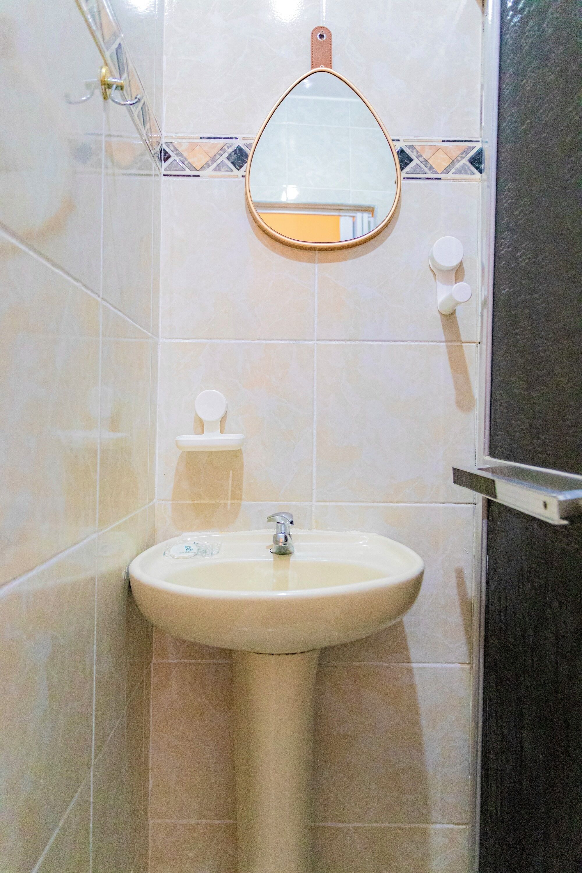 Ein Badezimmer mit Waschtisch, Spiegel und Toilette.
