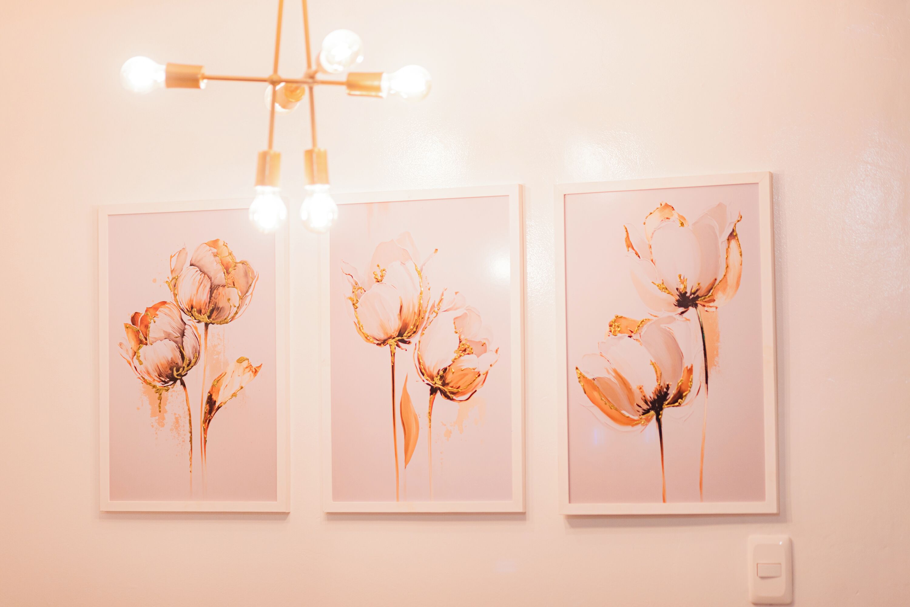 Tres cuadros con motivos florales en una pared.