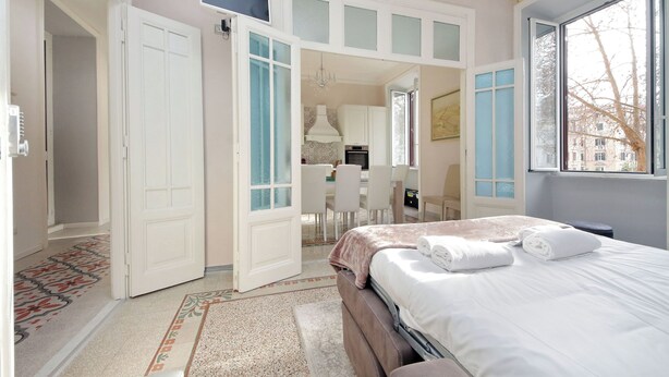 A bedroom with a bed, a desk, and a chair.