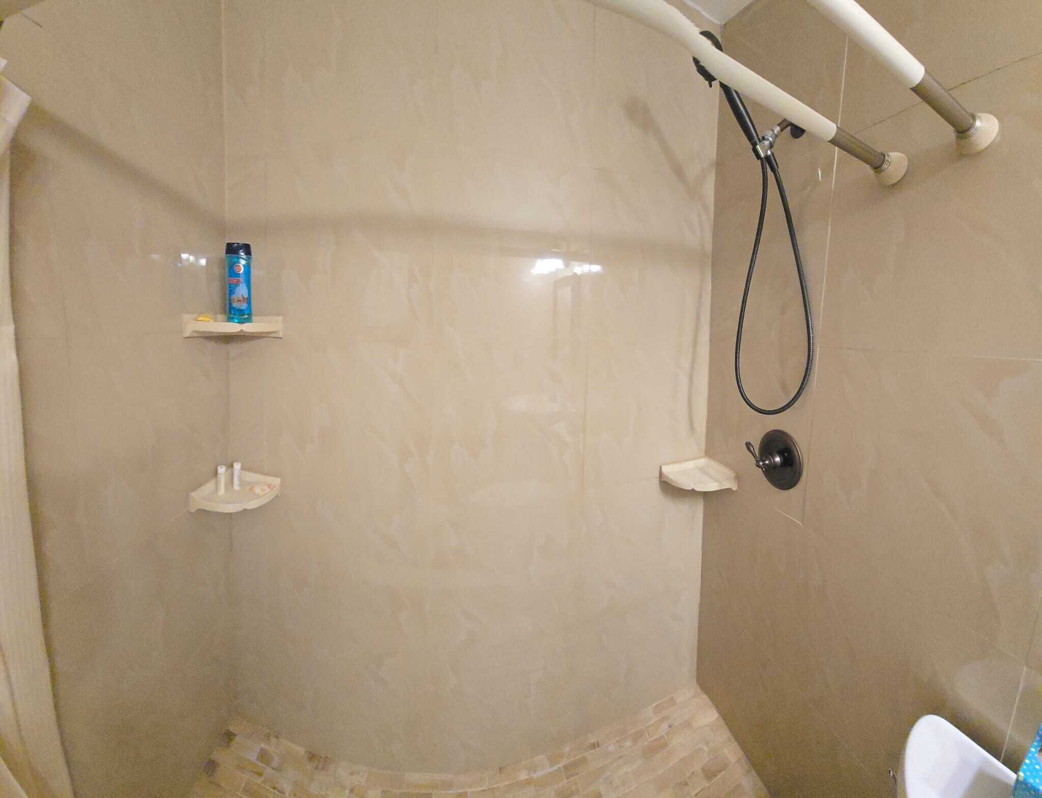 Een douche, handdoeken, zeep, toiletpapier