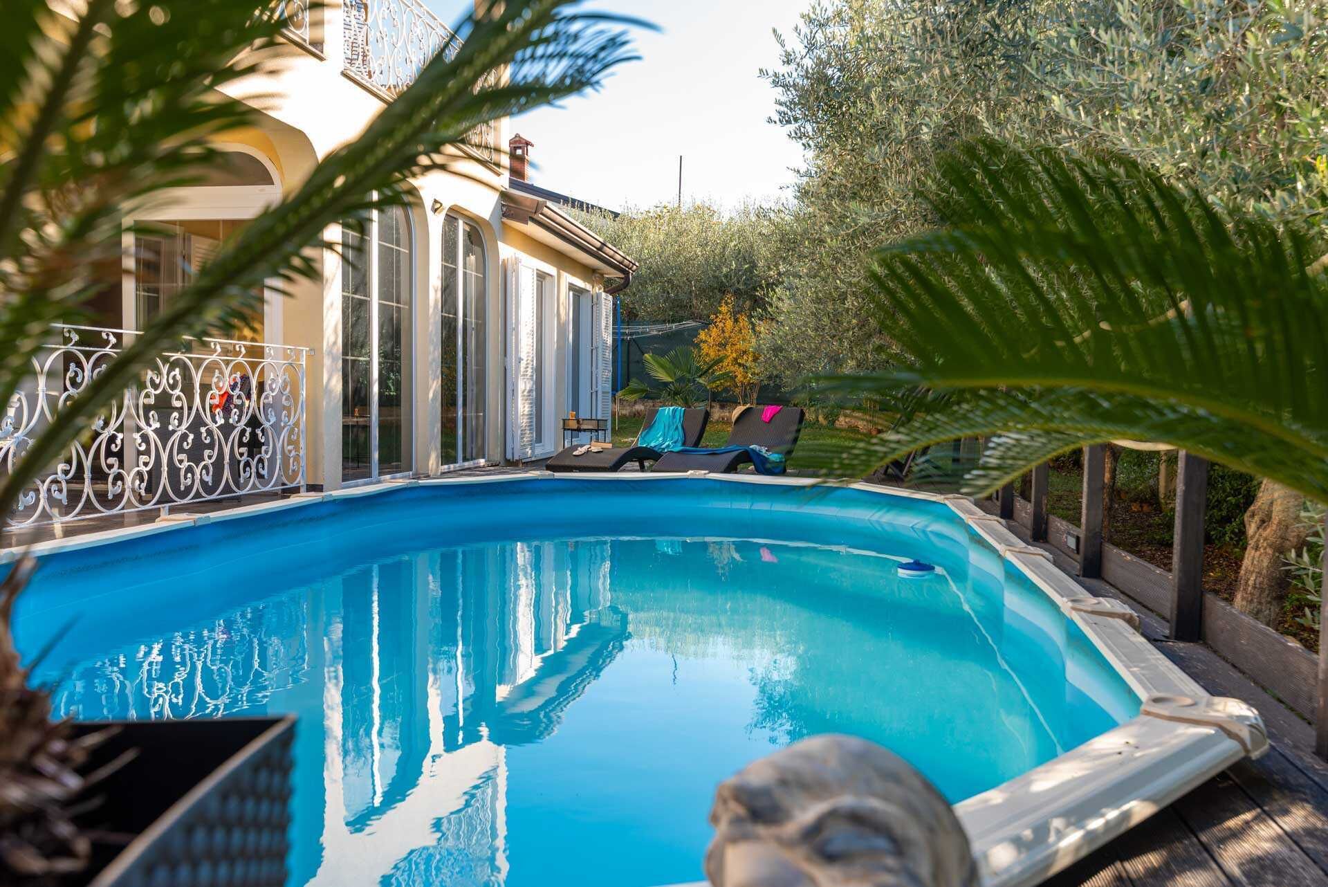 A swimming pool with lounge chairs and a decorative fence.