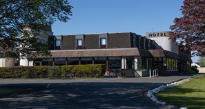 A hotel with a modern design, featuring a flat roof, large windows, and a sign indicating it is a hotel.