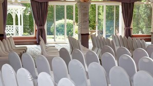 A room with rows of white chairs, large windows, and a white gazebo outside. - Best Western Glasgow Livingston Hilcroft Hotel (Bathgate)