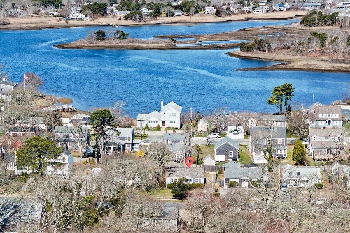 A residential area with houses near a large body of water, likely a lake or river.