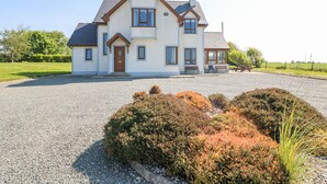 A two-story house with a gravel driveway and a well-maintained garden. - Lacey's Harbour (Battlestown)