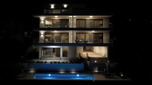 Una casa moderna de varios pisos con piscina al frente.