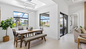 Ein modernes Wohnzimmer mit Essbereich, großen Fenstern und Blick ins Freie.
