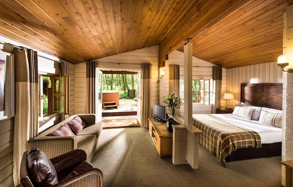 A cozy room with a bed, a sofa, a television, and a desk. - Chevin Country Park Hotel (Otley)