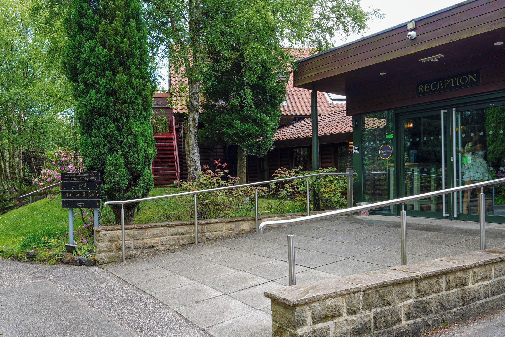 A reception area with a sign indicating directions to the car park, spa, pool & gym, and exit.