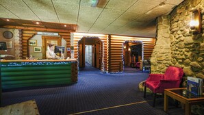 Un espace d’accueil avec un bureau en bois, une enseigne indiquant « réception » et un mur en pierre.