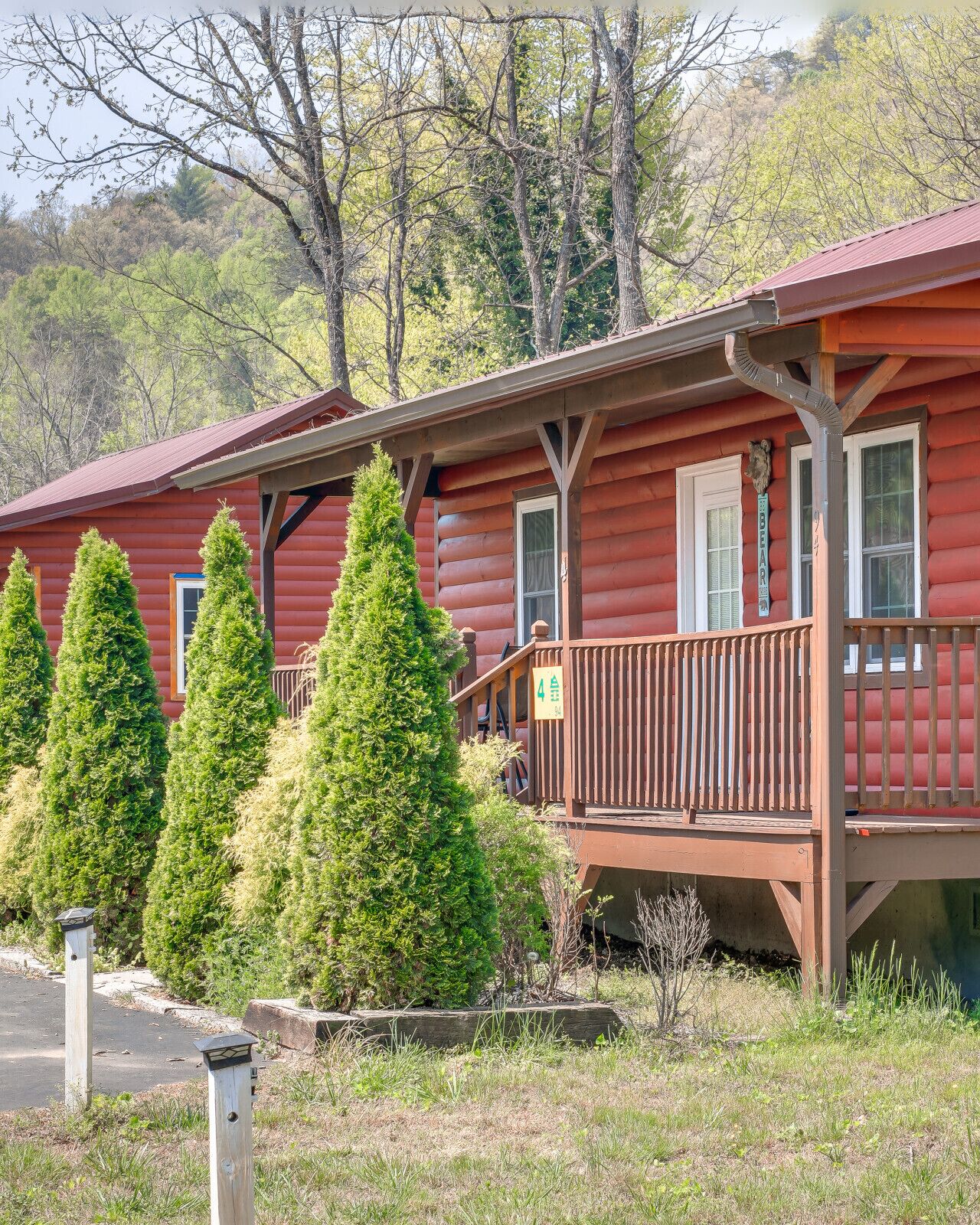 A log cabin with a wooden deck and a sign indicating room number 4.
